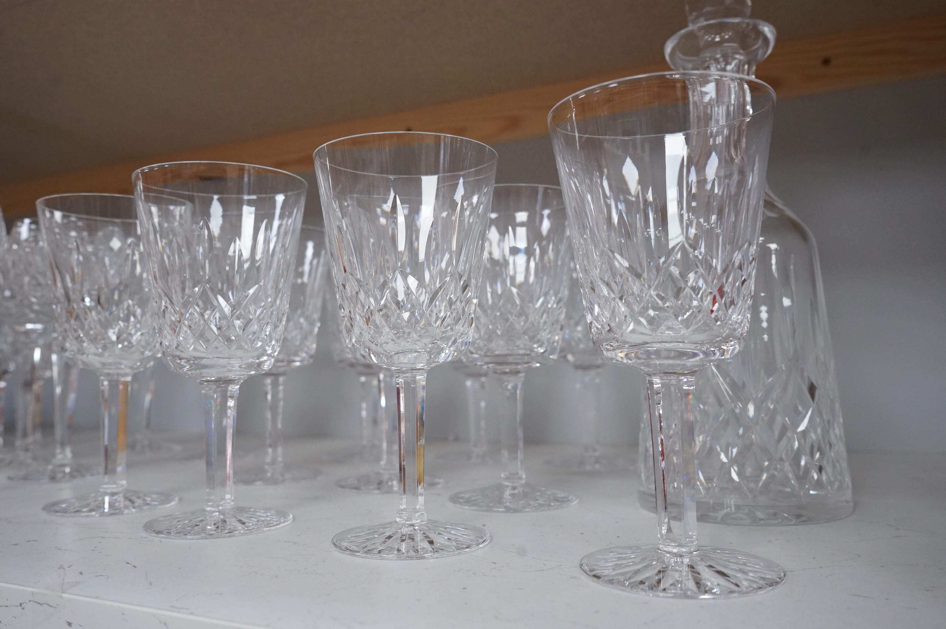 Twenty two Waterford Crystal company wine glasses and a decanter, 33cm